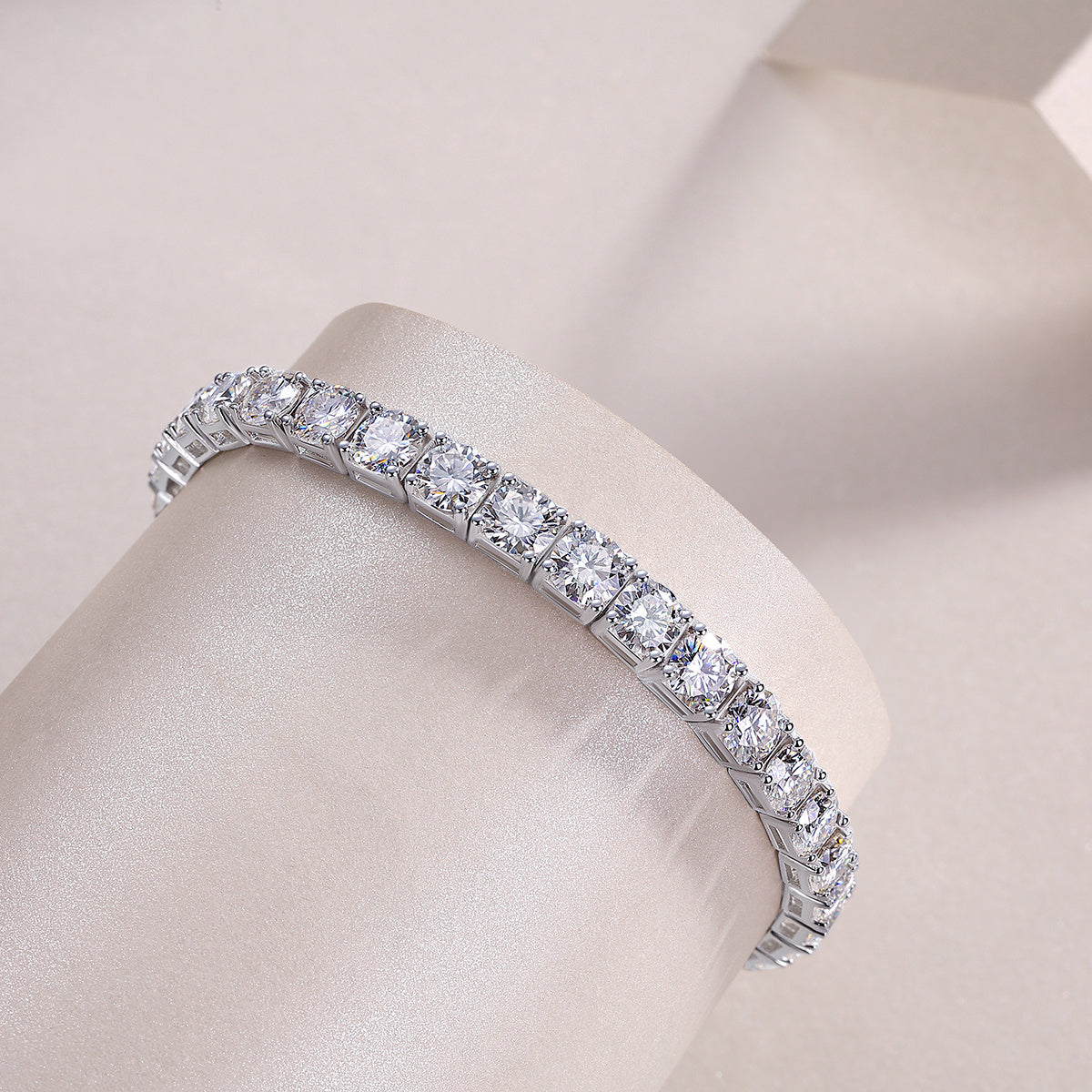 Diamond tennis bracelet on a mannequin arm against a neutral background