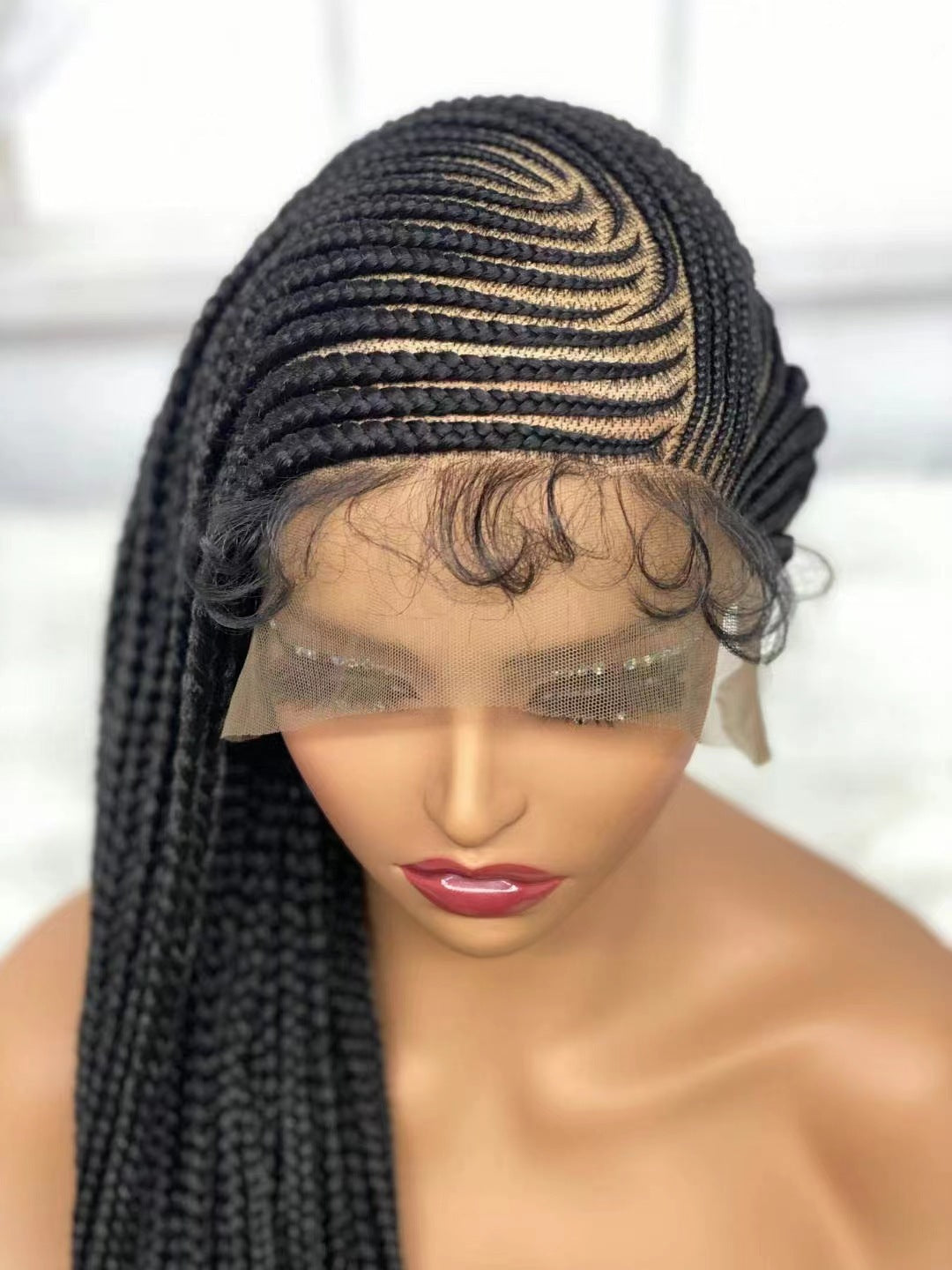 Black braided wig on a mannequin head with a blurred background