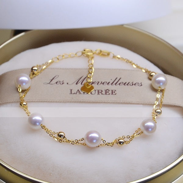 Gold bracelet with pearls on a branded stand