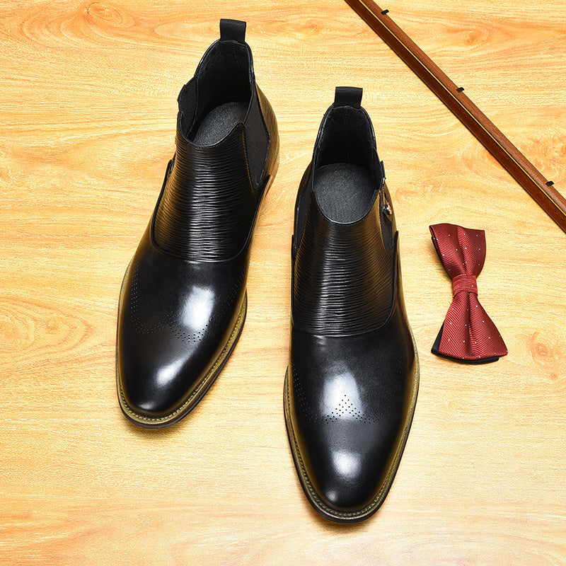Black leather shoes and a red bow tie on a wooden surface