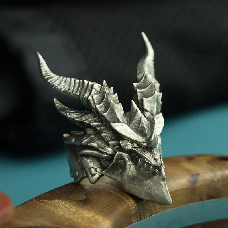 Silver dragon head ring on a wooden stand with a blurred background