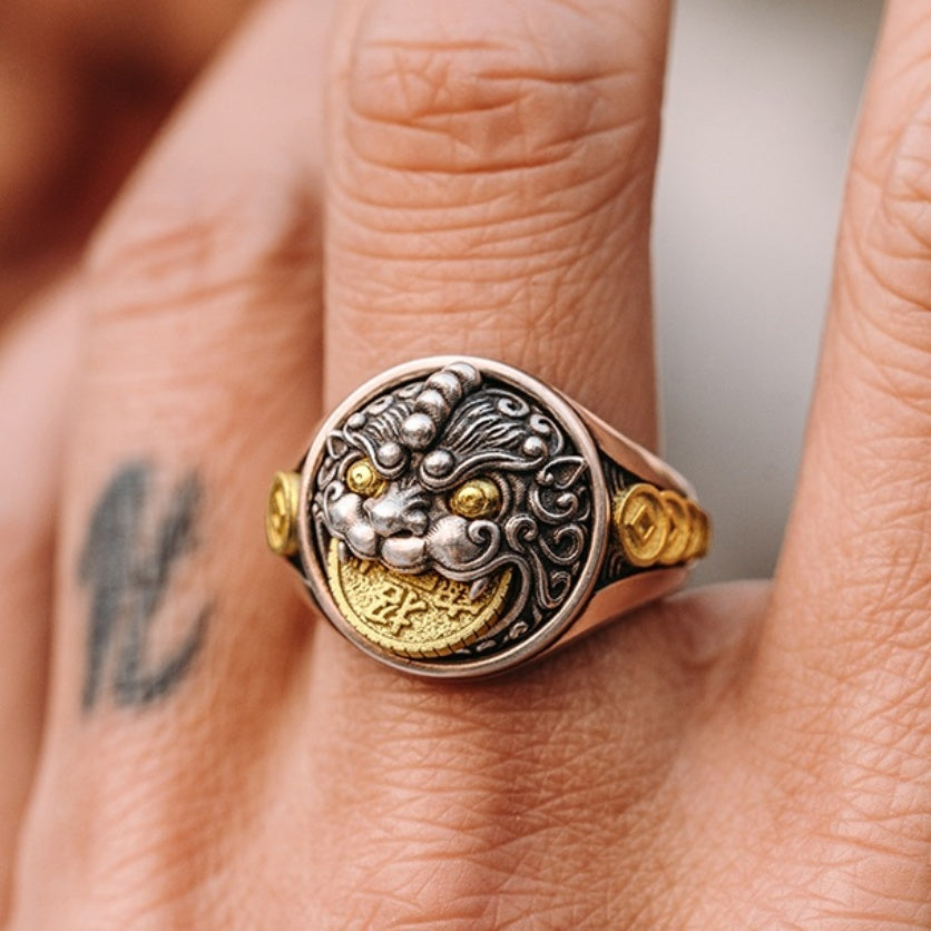 Close-up of a hand wearing a decorative gold and silver ring.