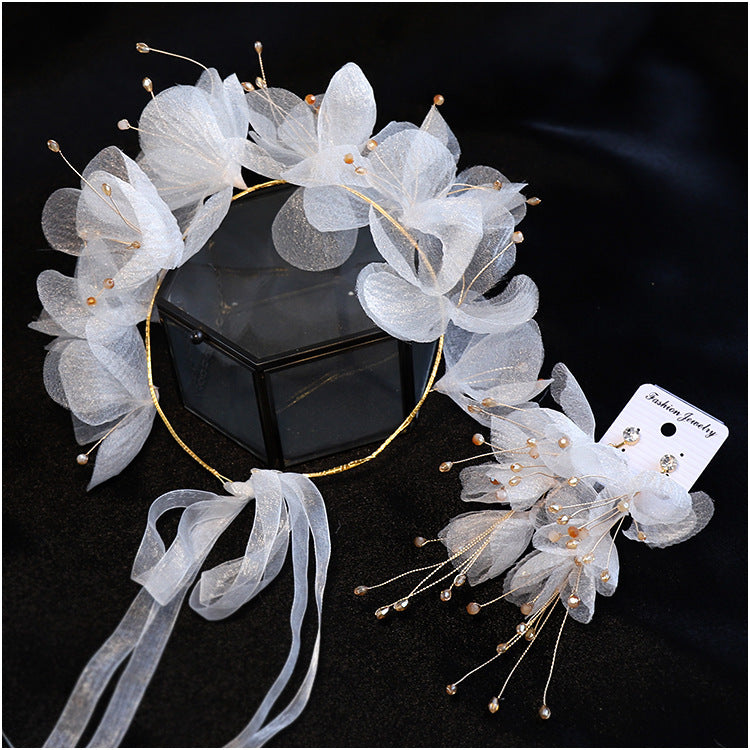 White floral headpiece with ribbons on a black background