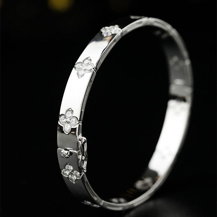 Silver bracelet with floral designs on a black background