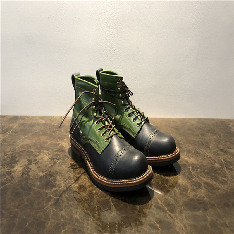 Green and black leather boots on a textured surface with a neutral background