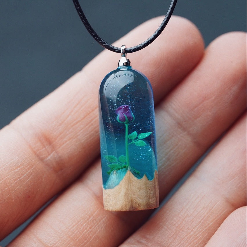 Resin pendant with a rose design held between fingers