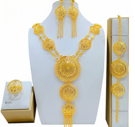 Gold jewelry set including necklace, earrings, and ring on a white background