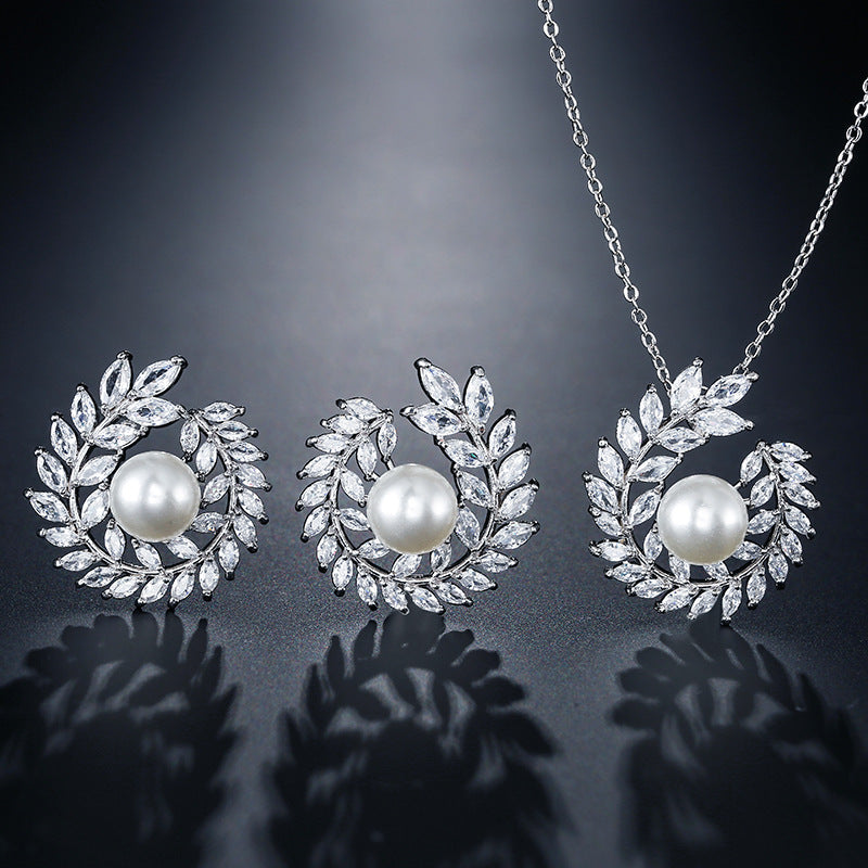 Pearl necklace and earrings set on a dark background