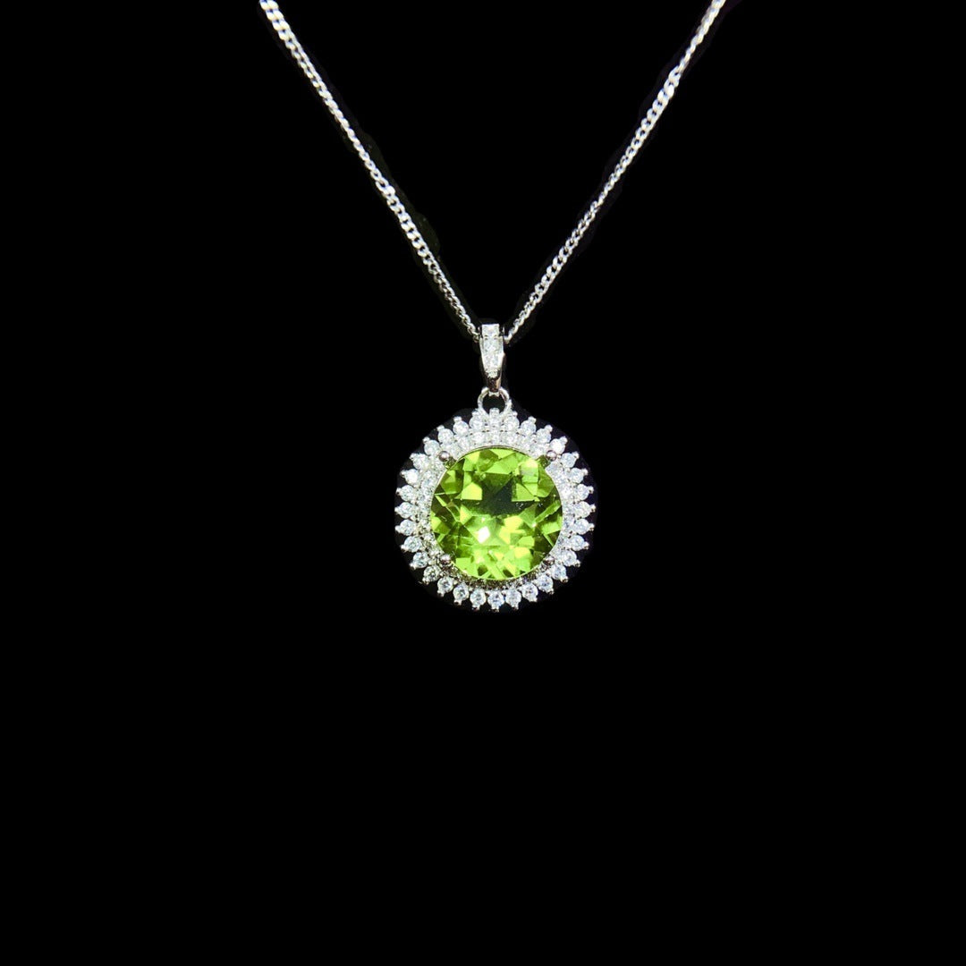 Green gemstone pendant on a chain against a black background