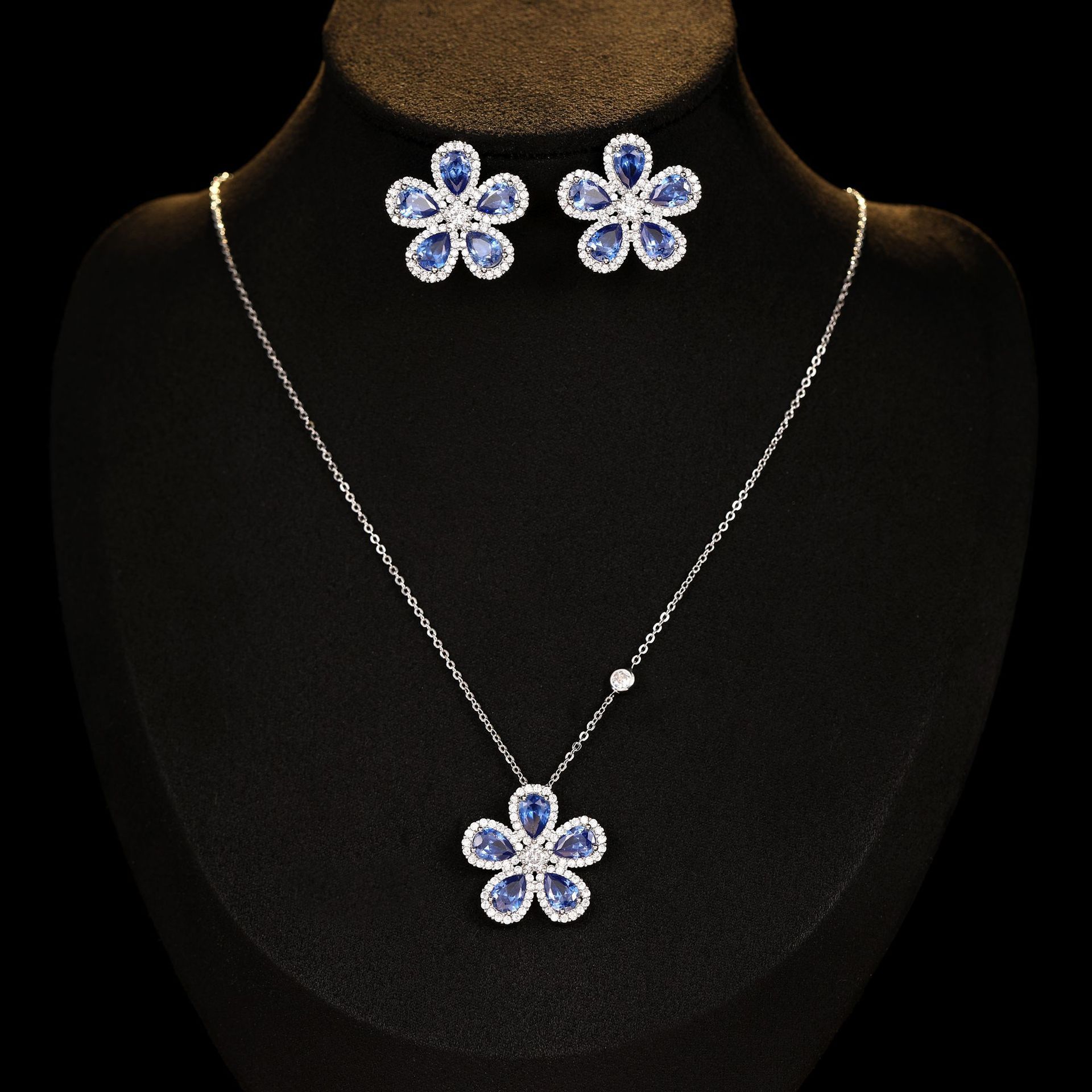 Jewelry set with flower-shaped necklace and earrings on a black background