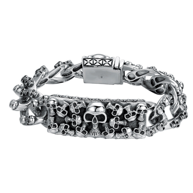 Silver bracelet with skull designs on a white background