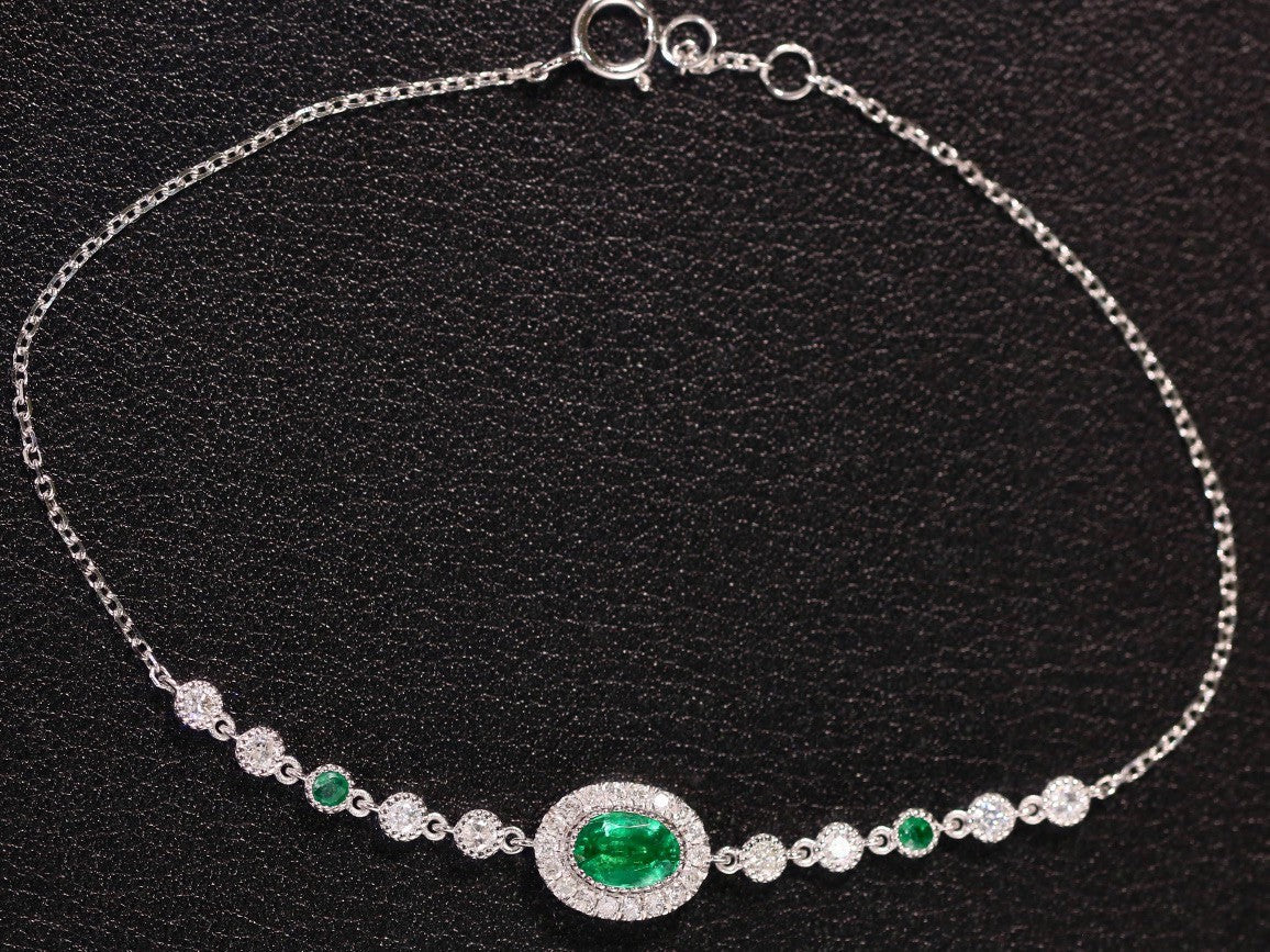 Silver bracelet with green gemstone on a black background