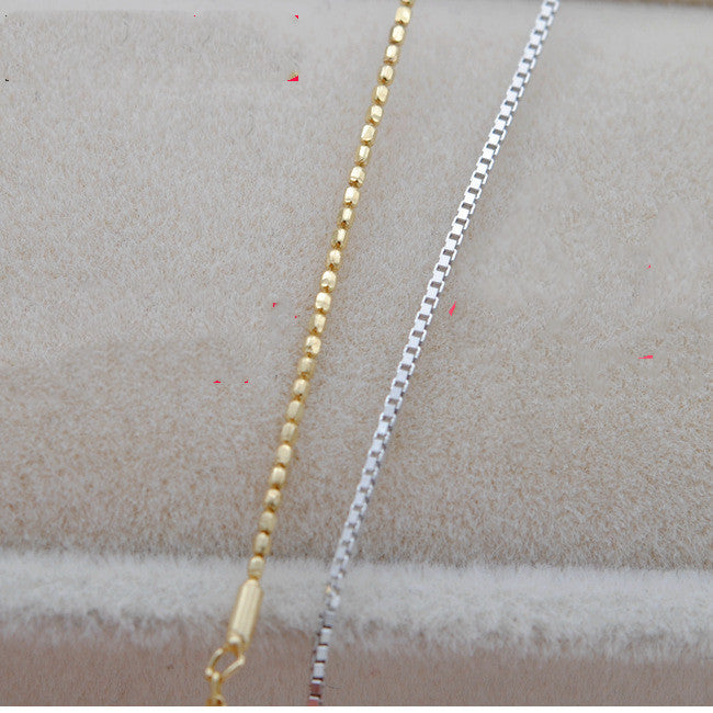 Gold and silver chains on a textured surface