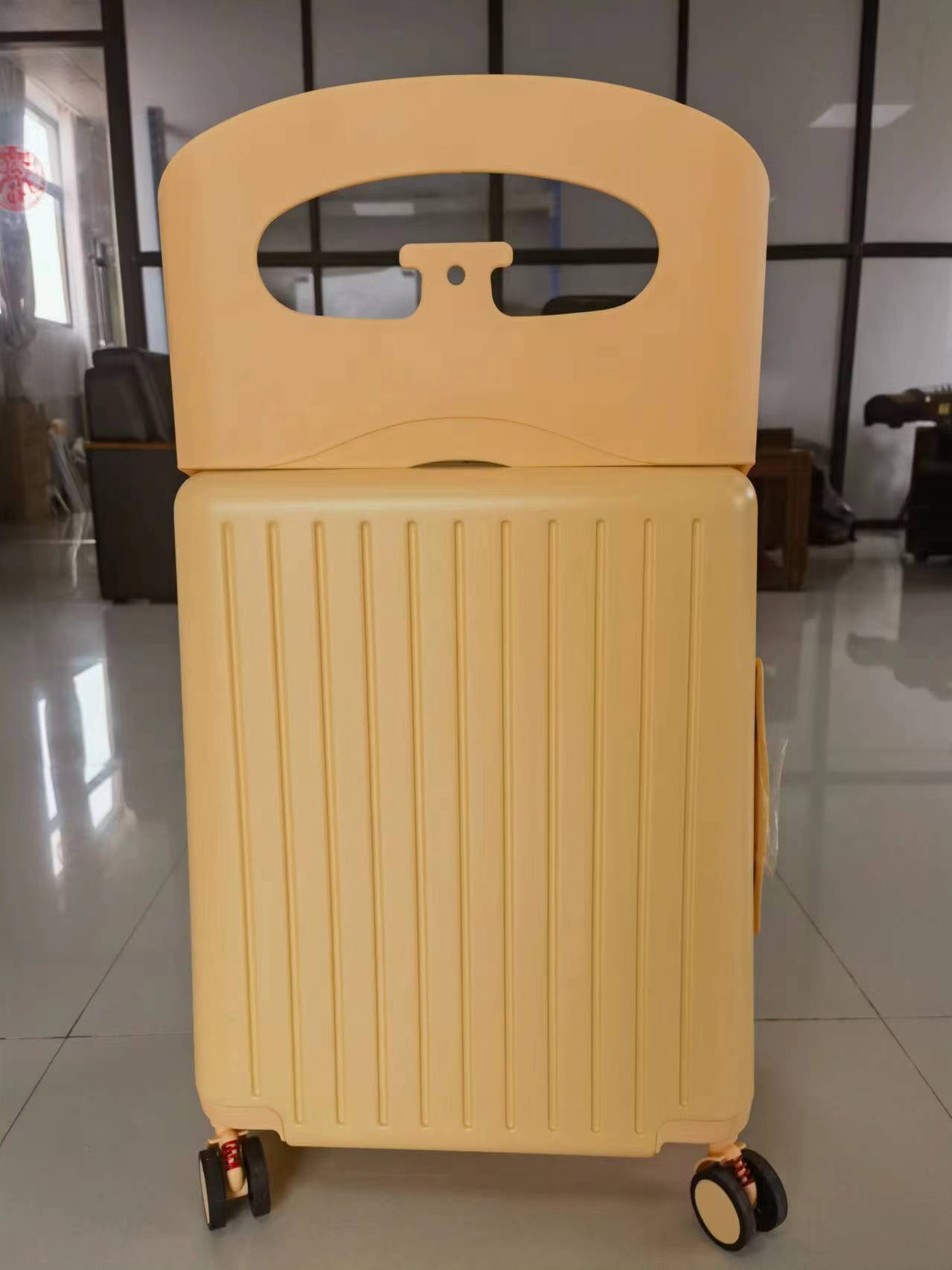 Yellow suitcase with wheels on a tiled floor
