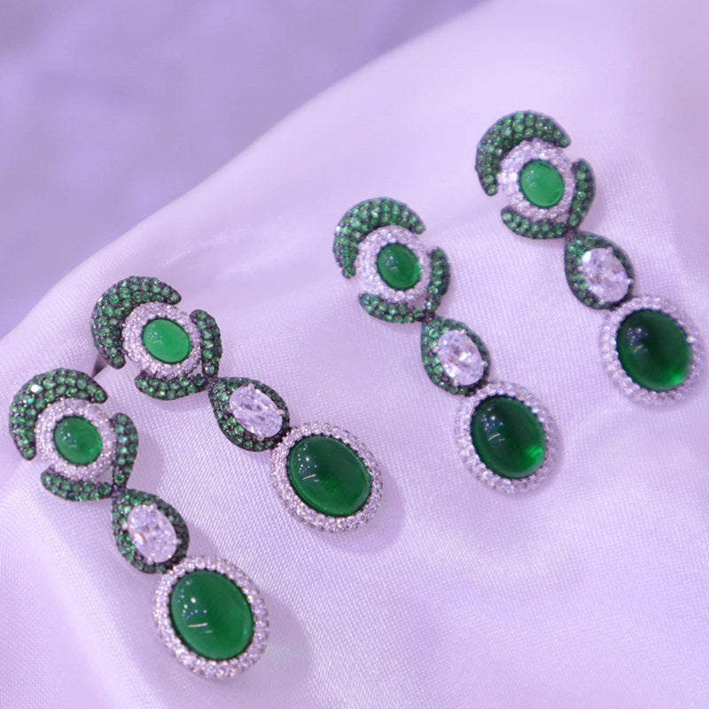 Green gemstone earrings on a white fabric background