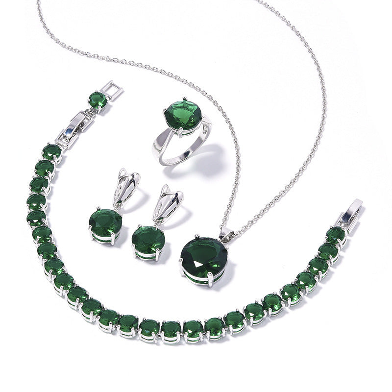 Jewelry set with green gemstones on a white background