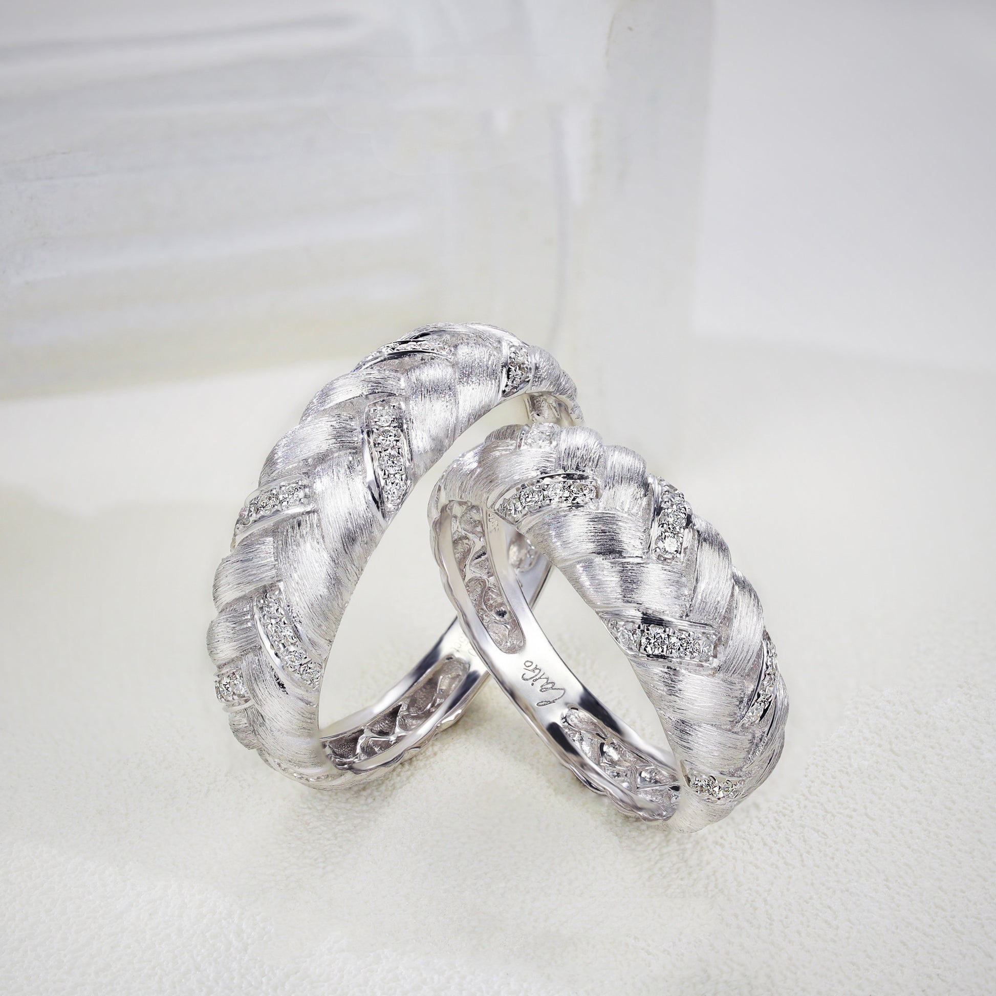 Two silver rings with diamond accents on a white background
