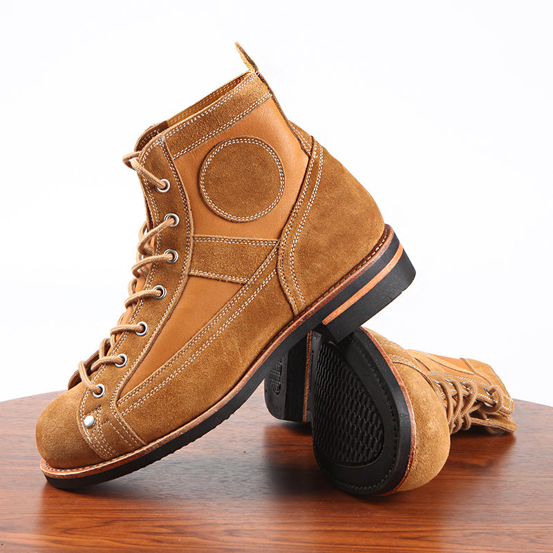 Brown leather boots with black soles on a wooden surface