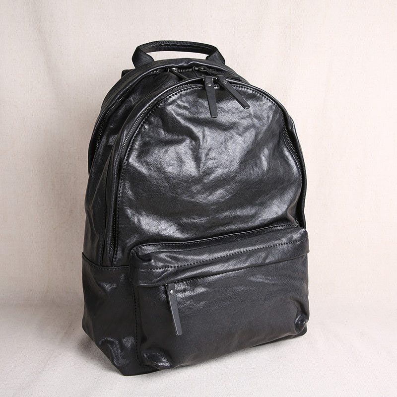 Black leather backpack on a light beige background