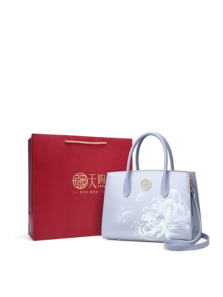 White handbag with floral design and red gift box on a white background
