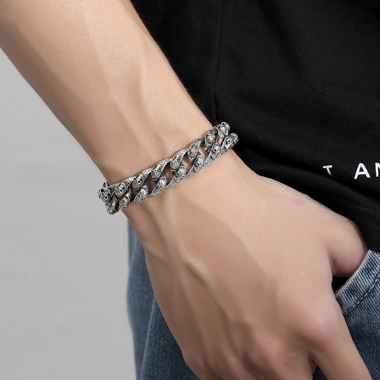 Silver chain bracelet on a wrist with a neutral background