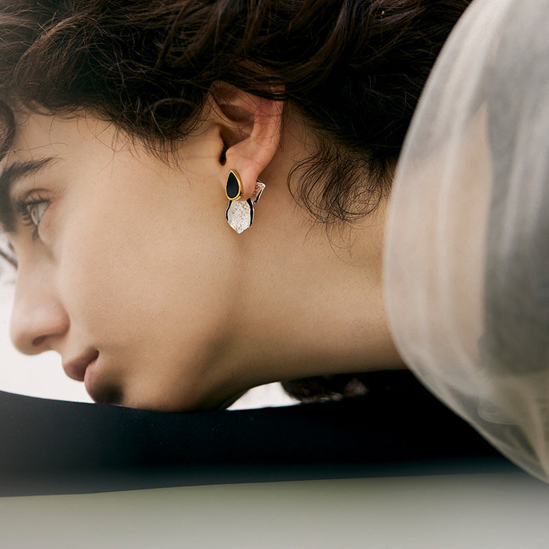 Close-up of a person wearing earrings with a blurred background