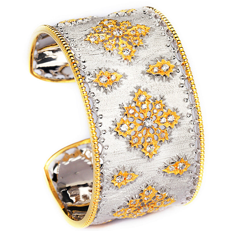 Decorative cuff bracelet with gold and silver design on a white background