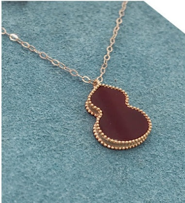 Necklace with a red pendant on a textured blue background