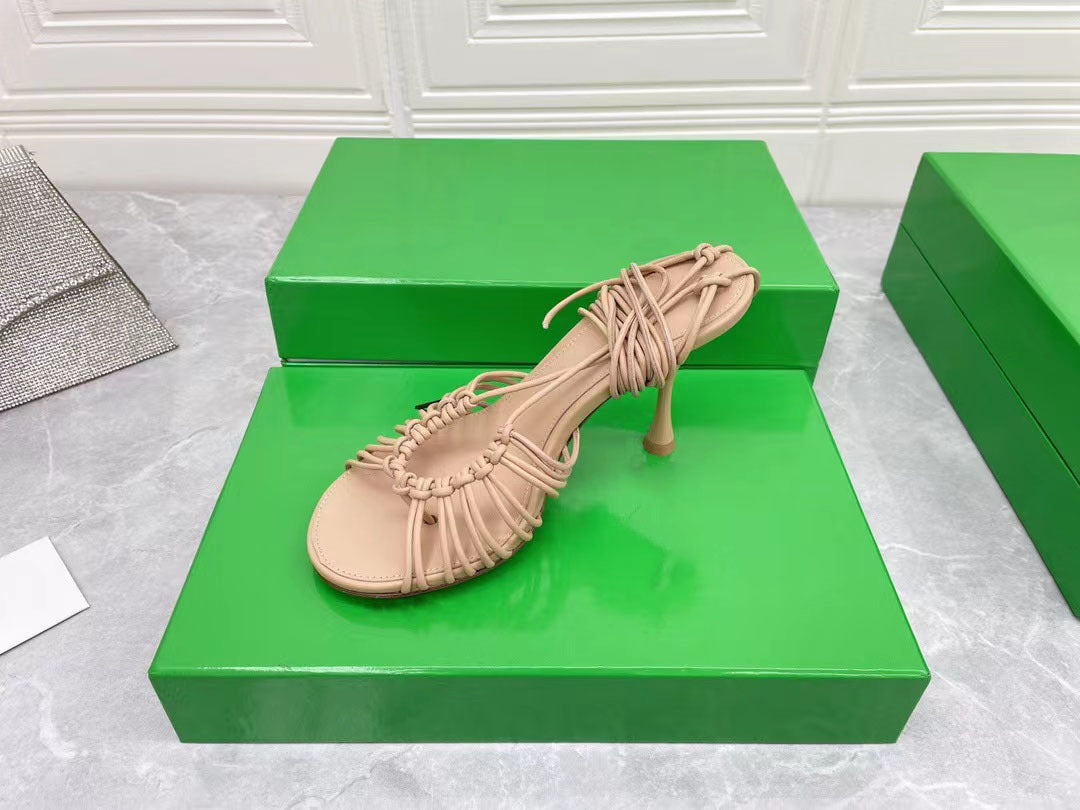 Beige sandal on a green box with a white background