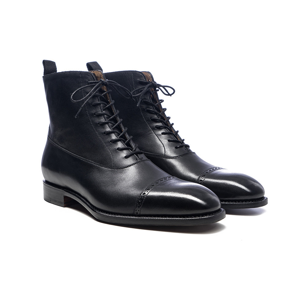 Pair of black leather boots on a white background
