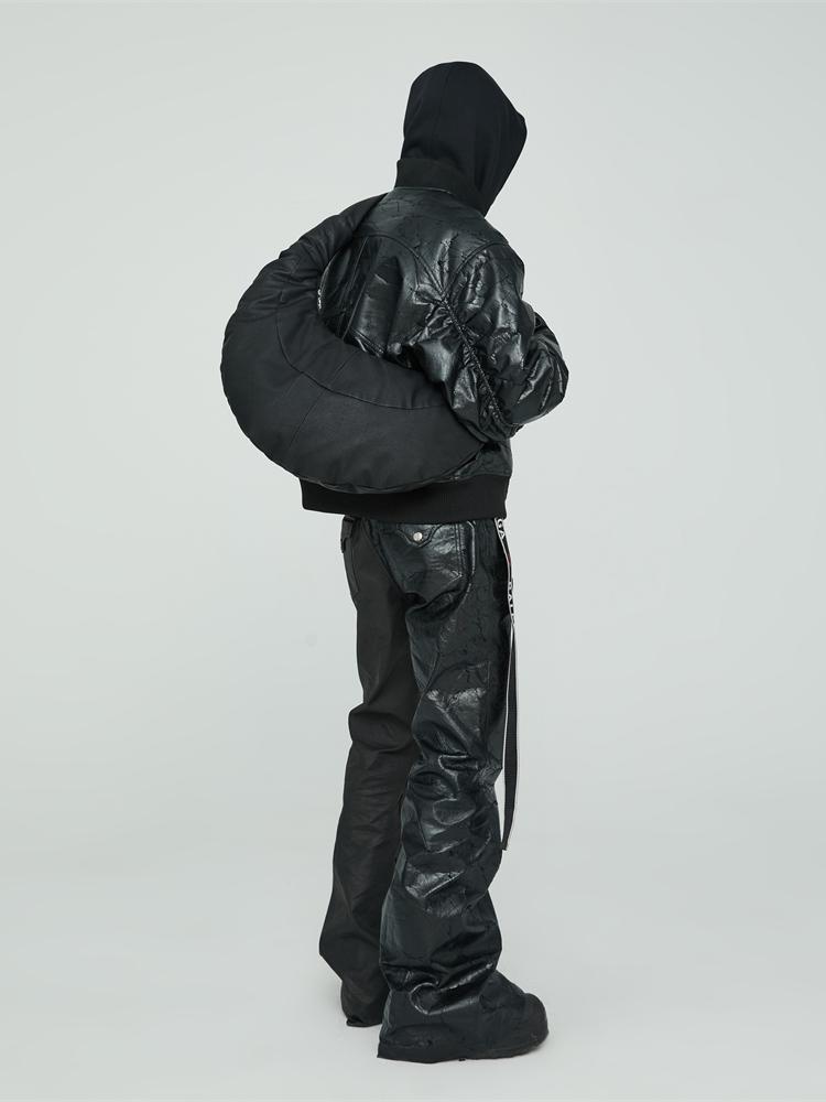 Person wearing a black hooded jacket and pants on a white background