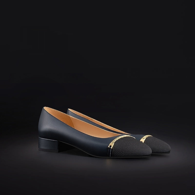 Black shoes with gold accents on a black background