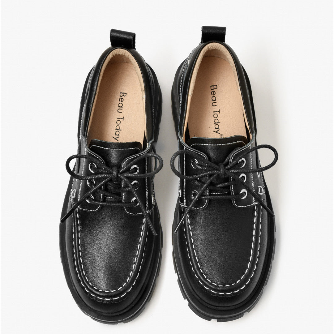 Pair of black leather shoes with lace-ups on a white background