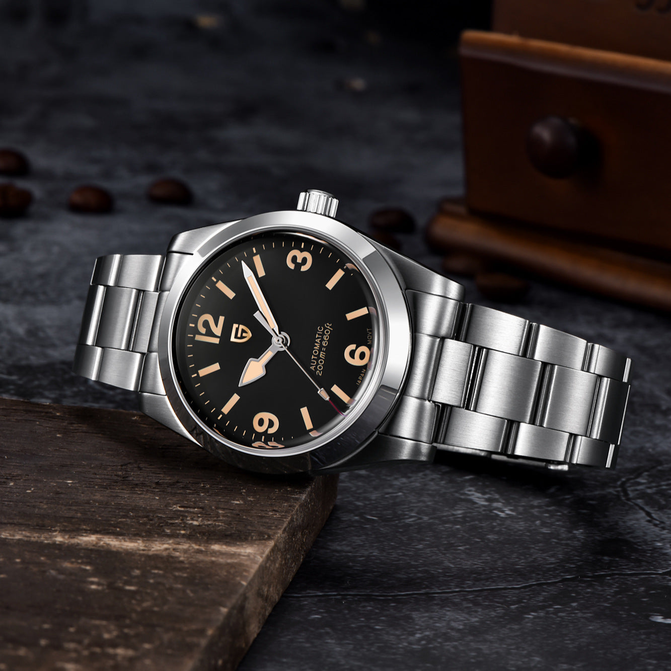 Silver wristwatch with black dial on a dark textured surface