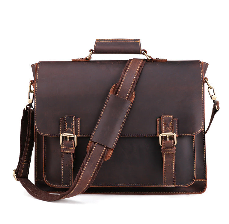 Brown leather satchel bag with gold buckles on a white background