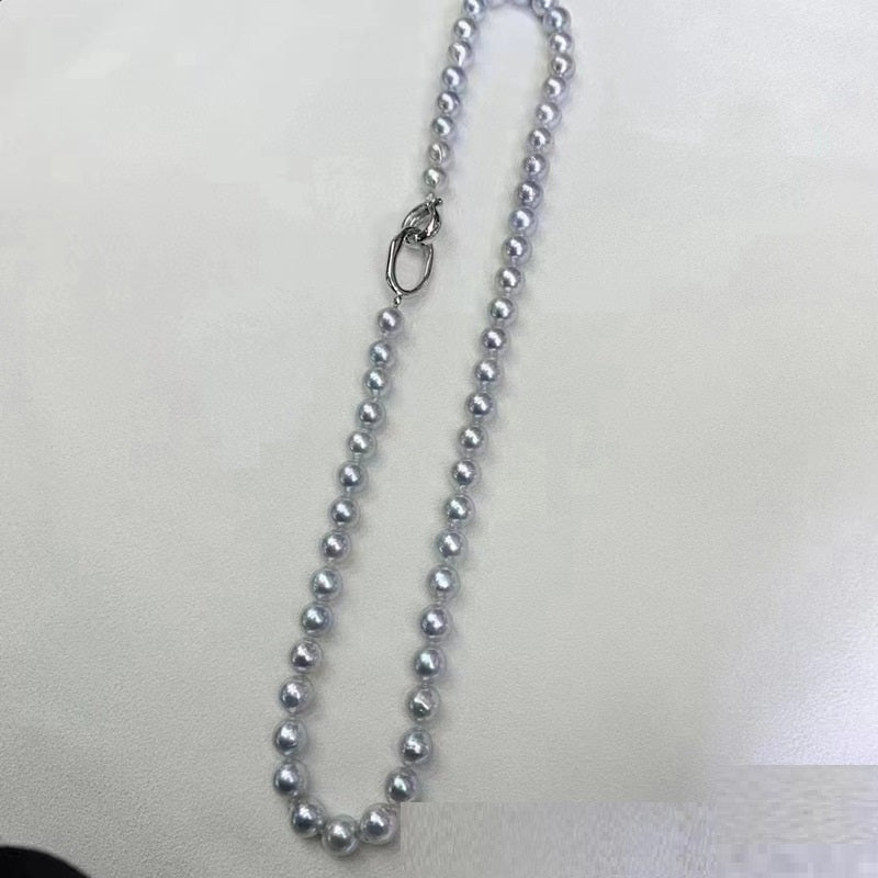 Silver beaded necklace on a plain background