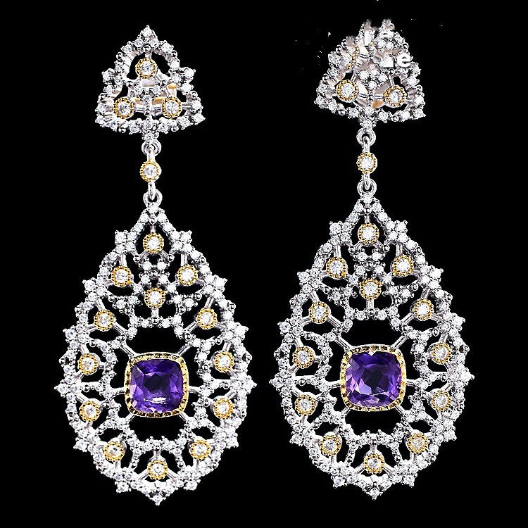 Pair of ornate earrings with purple gemstones on a black background