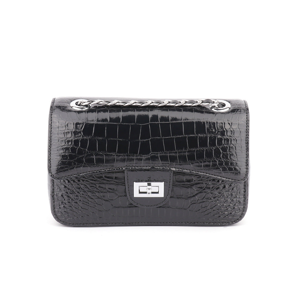 Black crocodile-patterned handbag with silver clasp on a white background