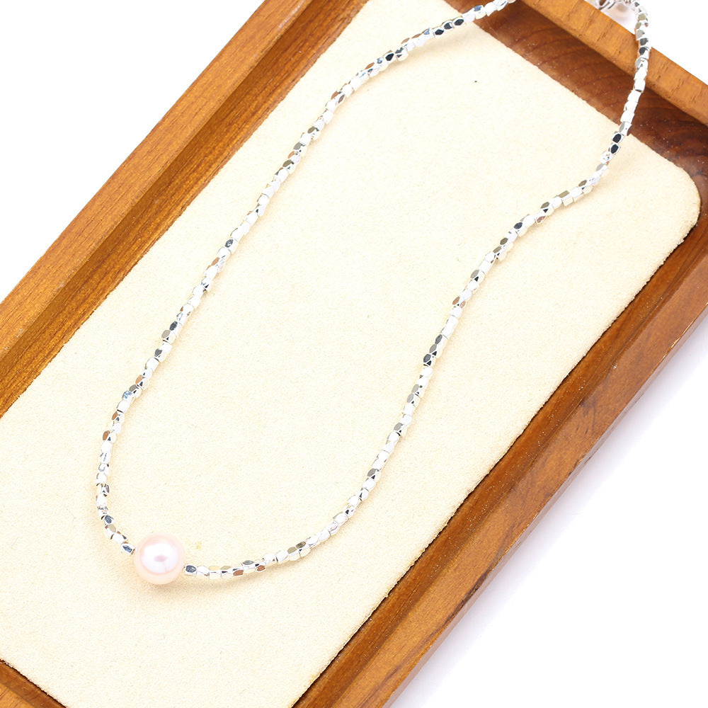 Necklace with a pearl pendant on a wooden tray