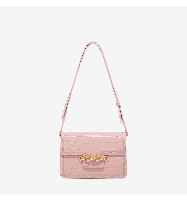 Pink handbag with a gold clasp on a light gray background