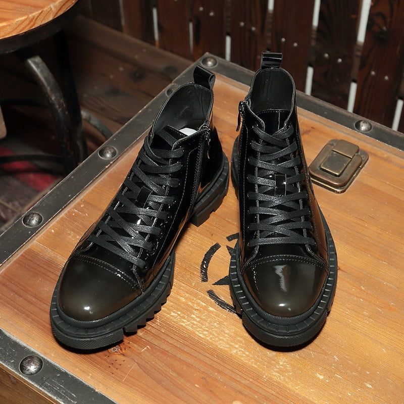 Pair of black high-top shoes on a wooden surface with a metal suitcase.