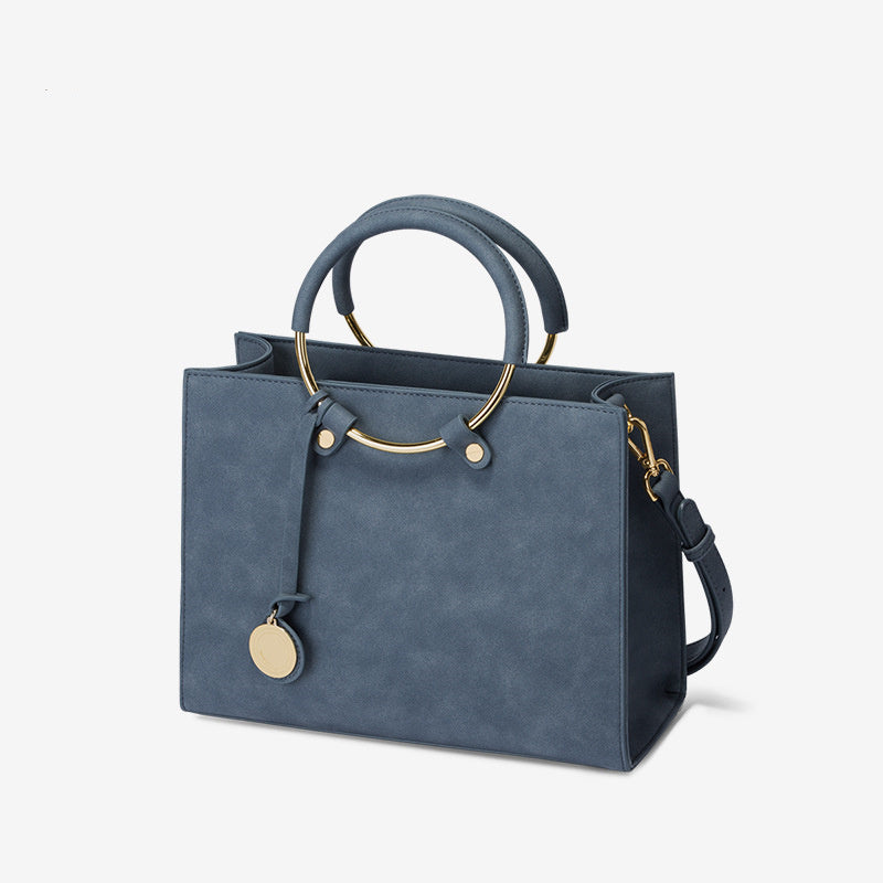 Blue handbag with gold accents on a light gray background