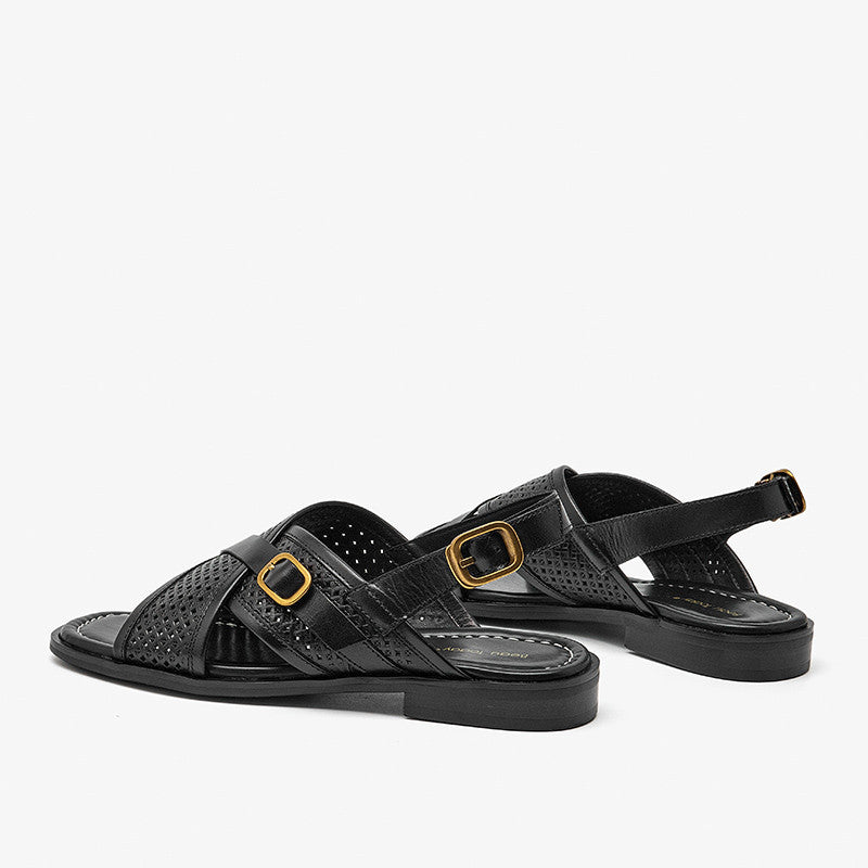 Black sandals with gold buckles on a white background