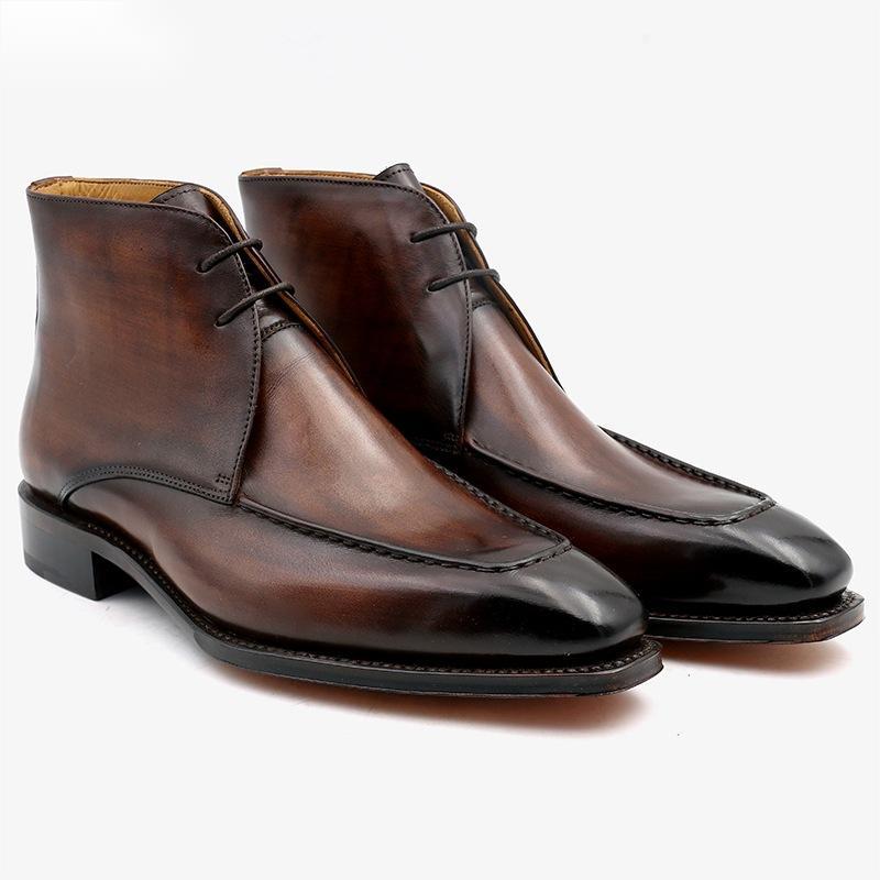 Pair of brown leather dress boots on a white background