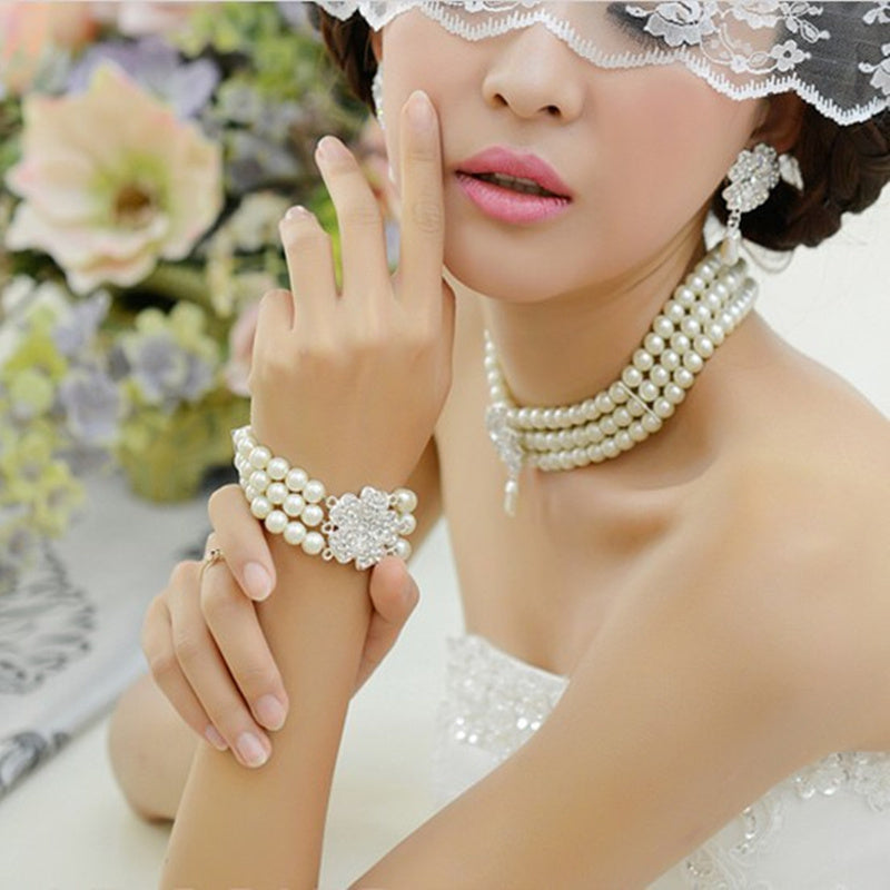 Woman wearing pearl jewelry with a blurred floral background