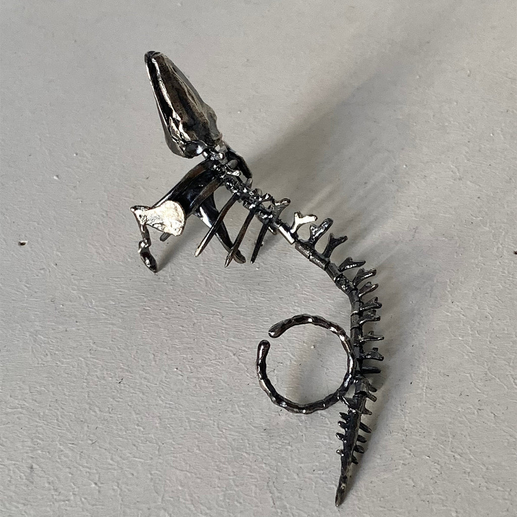 Silver spike earring on a light gray background