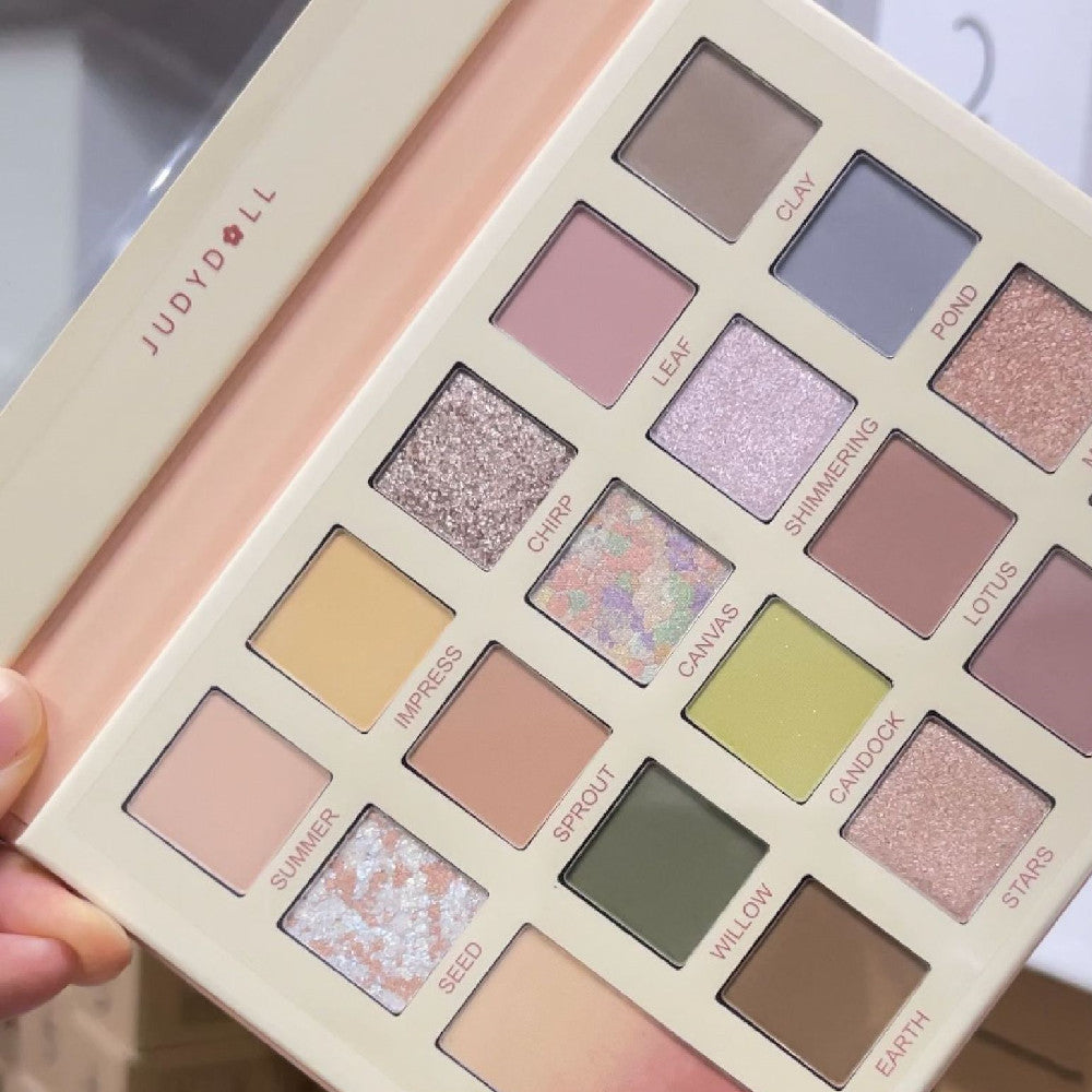 Makeup palette with various shades held by a hand