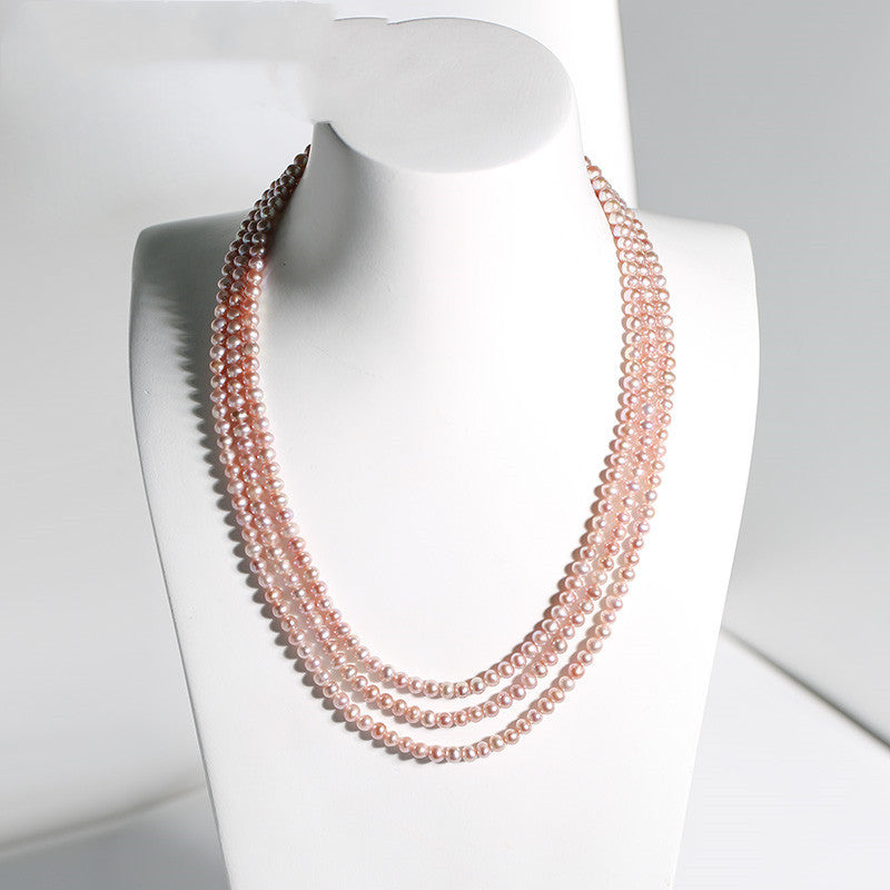 Multi-strand pearl necklace on a mannequin with a plain background