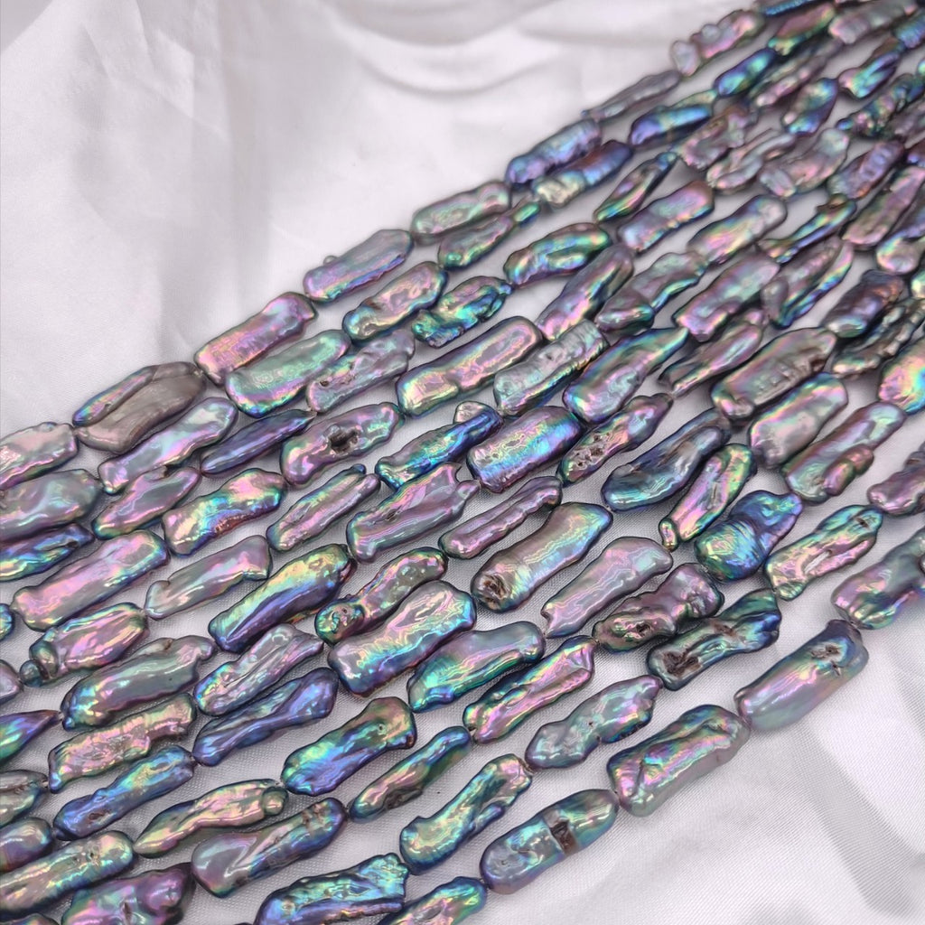 Iridescent shell beads on a white fabric background
