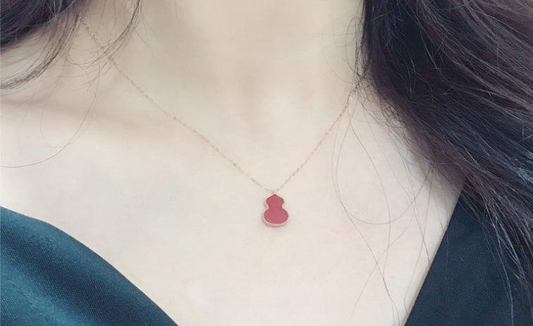 Necklace with a red heart pendant worn by a person
